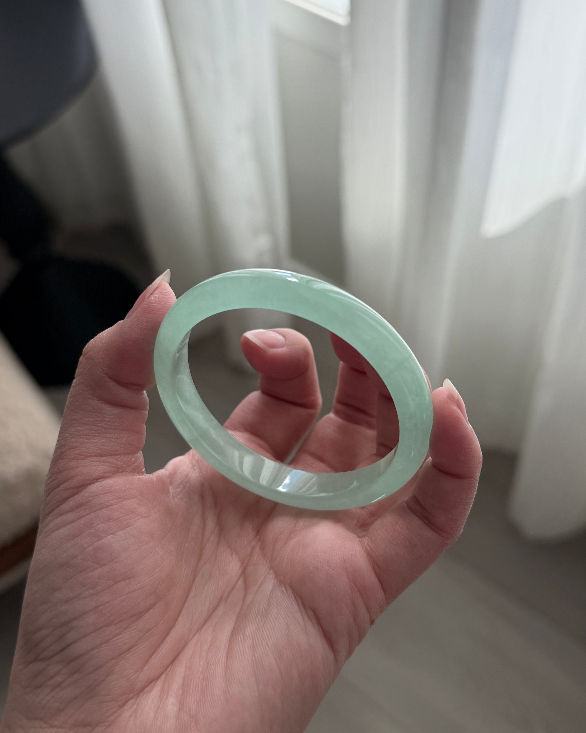 Hand holding a green adventurine bangle